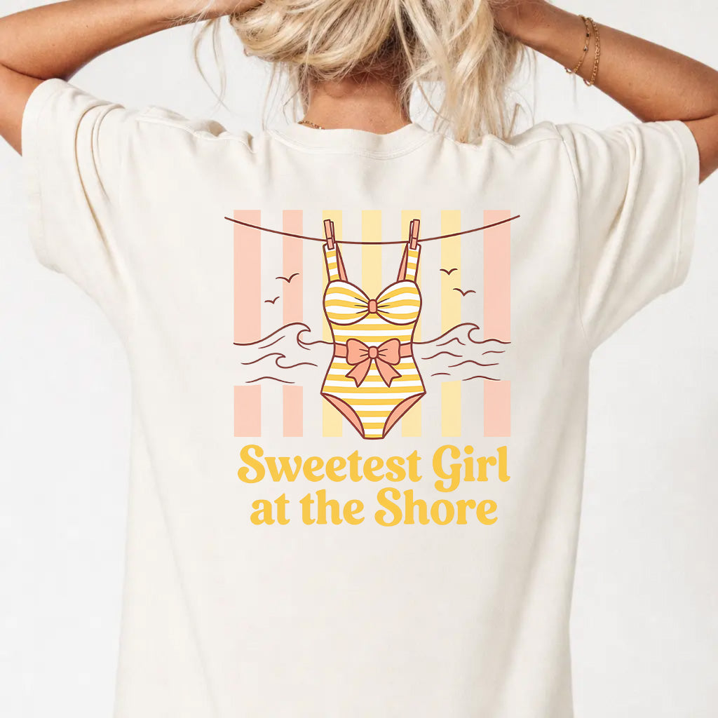 Woman wearing an ivory coastal cutie graphic tee with retro swimsuit clothesline back print