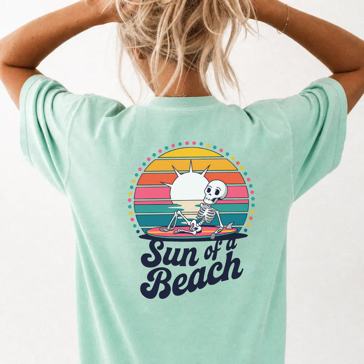 Woman wearing an island reef funny skeleton beach graphic tee with retro sunset back print