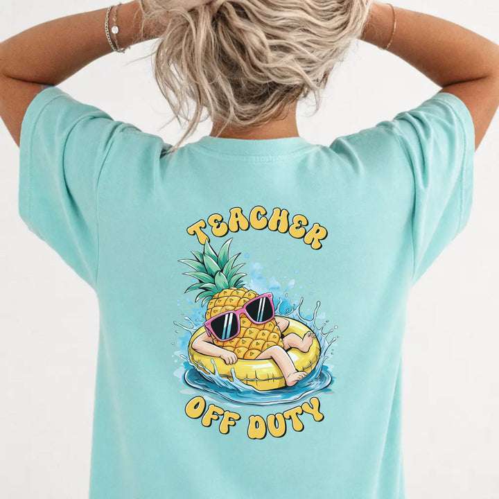 Woman wearing a chalky mint funny teacher graphic tee with pineapple pool float back print
