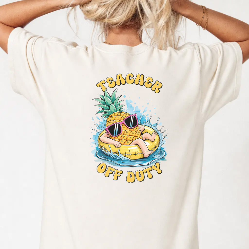 Woman wearing an ivory funny teacher graphic tee with pineapple pool float back print