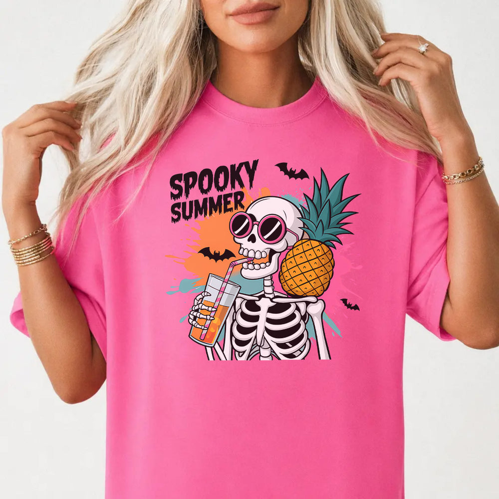 Woman wearing a neon pink halloween tropical skeleton women's graphic tee with a sunglasses-wearing skeleton holding a pineapple and drink front print