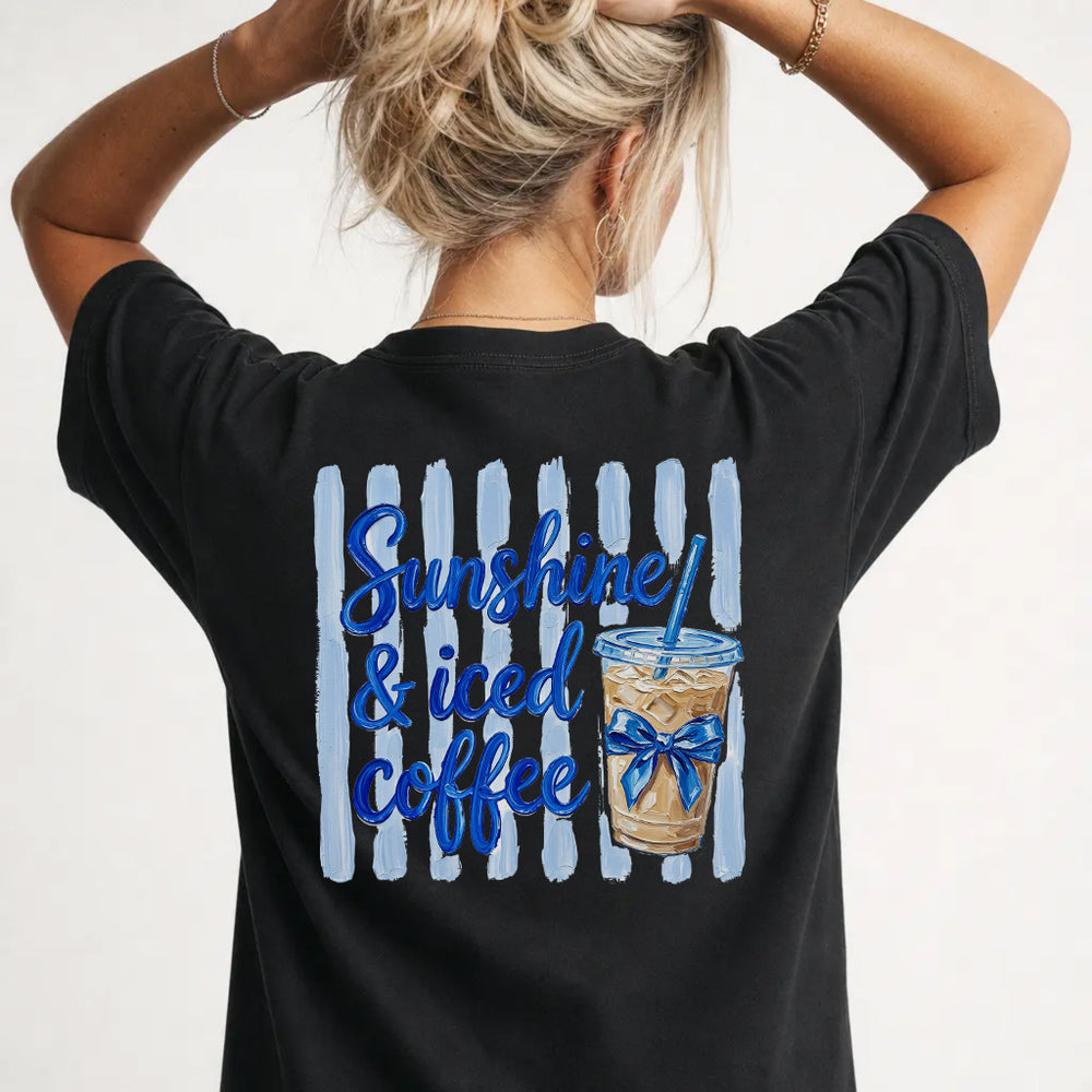 Woman wearing a black iced coffee lover graphic tee with painted coffee cup back print