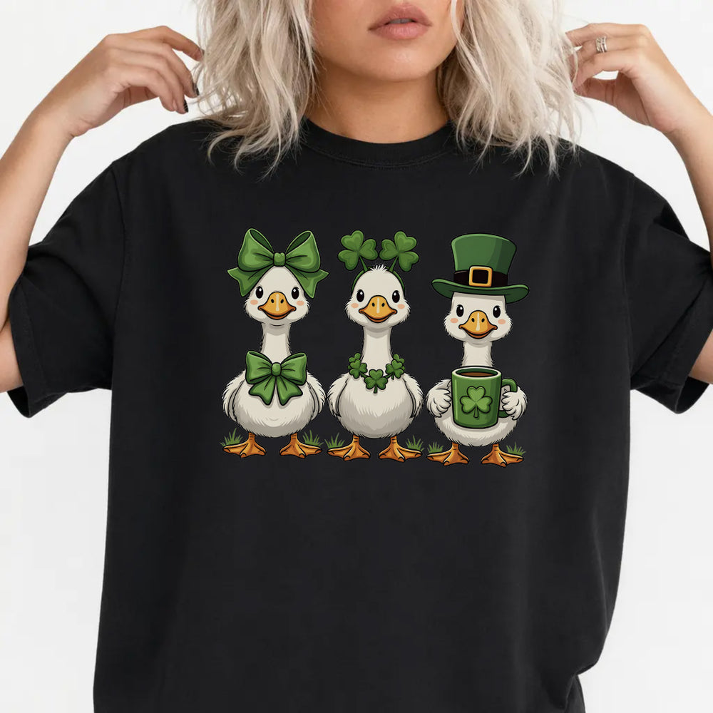 Woman wearing a black St. Patrick's Day cute duck trio women's graphic tee with three geese in bows shamrocks and leprechaun hat front print