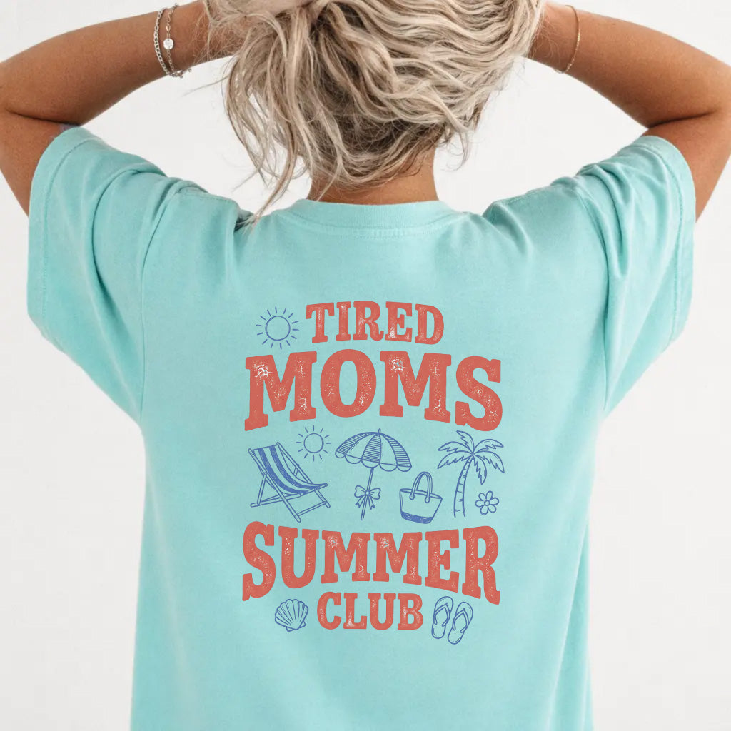 Woman wearing a chalky mint Tired Moms Summer Club graphic tee with beach doodle back print