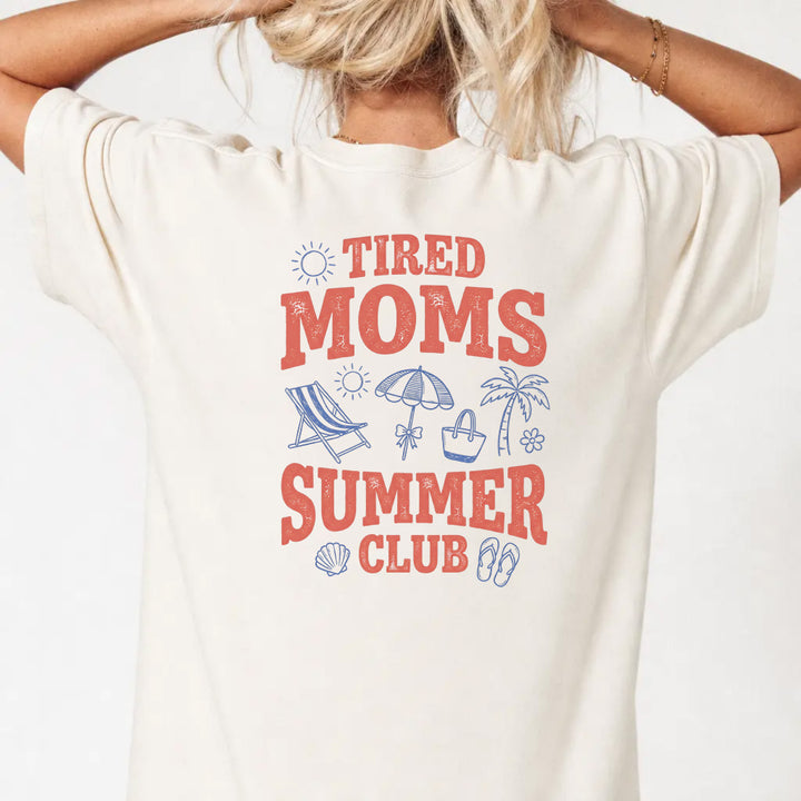 Woman wearing an ivory Tired Moms Summer Club graphic tee with beach doodle back print