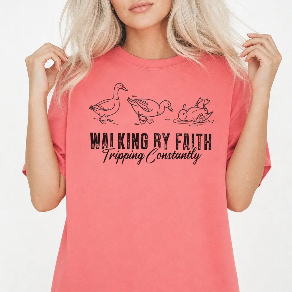 Woman wearing a watermelon shirt with three duck illustrations and the phrase Walking by Faith Tripping Constantly on the front