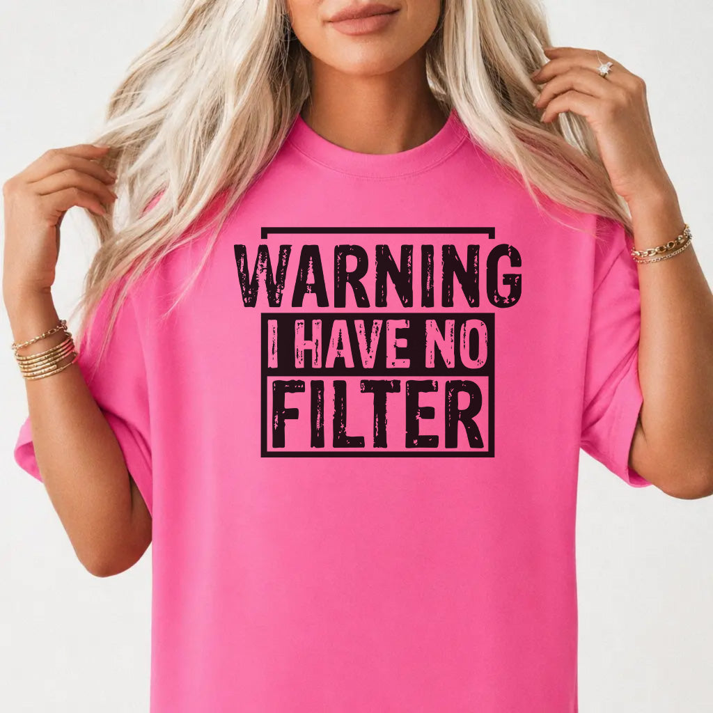 Woman wearing a neon pink shirt with bold distressed black lettering that reads Warning I Have No Filter on the front