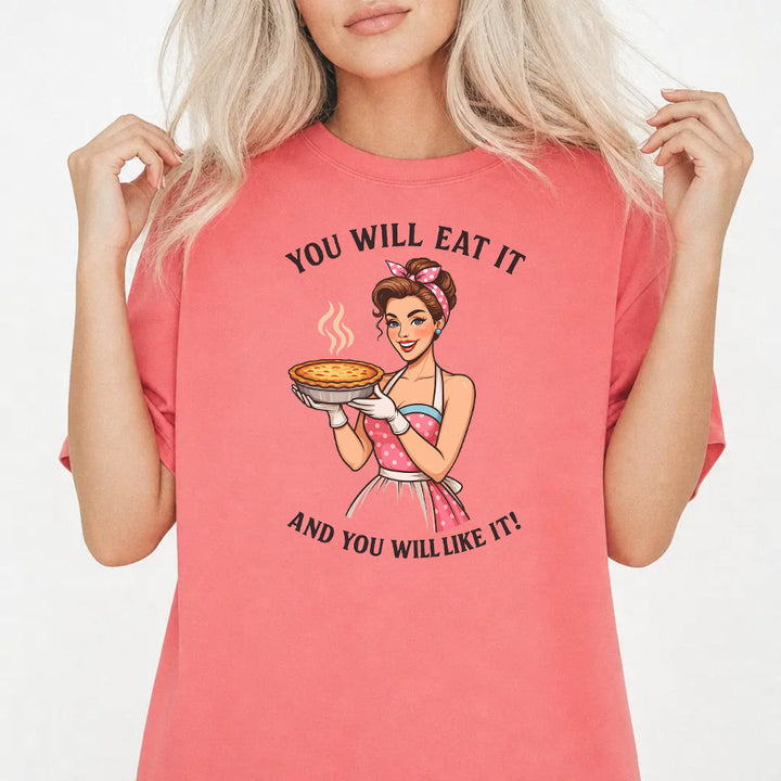 Woman wearing a watermelon graphic tee with a retro pin-up woman holding a pie and the phrase You Will Eat It and You Will Like It on the front